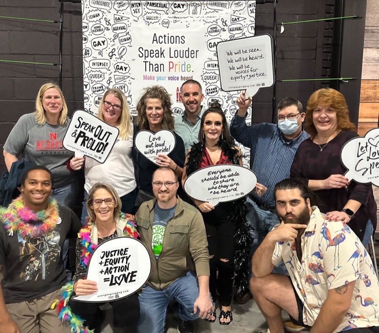 Group at Greensboro Pride holding speech-bubble signs